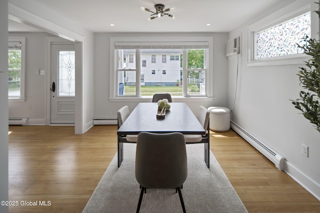 dining room with baseboard heating, light wood-style flooring, an AC wall unit, and recessed lighting