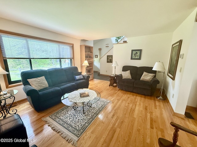 living room featuring plenty of natural light, light wood-style flooring, and baseboards