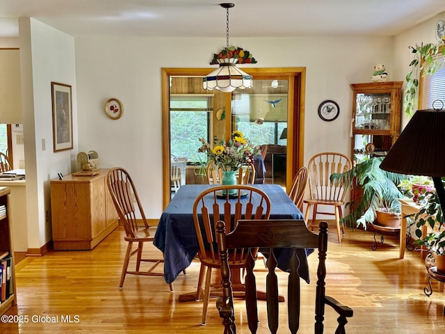 dining room featuring light wood-type flooring and baseboards