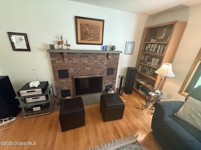 living area featuring wood finished floors and a brick fireplace