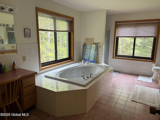 bathroom featuring tile patterned floors, tile walls, an enclosed shower, a garden tub, and a wainscoted wall