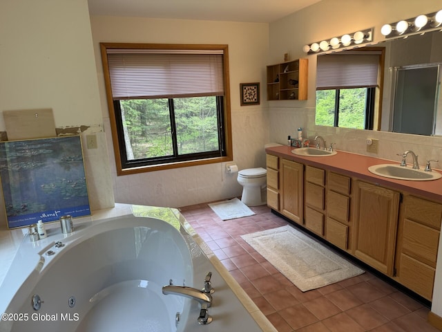 full bath with a tub with jets, tile patterned flooring, double vanity, a shower stall, and a wainscoted wall