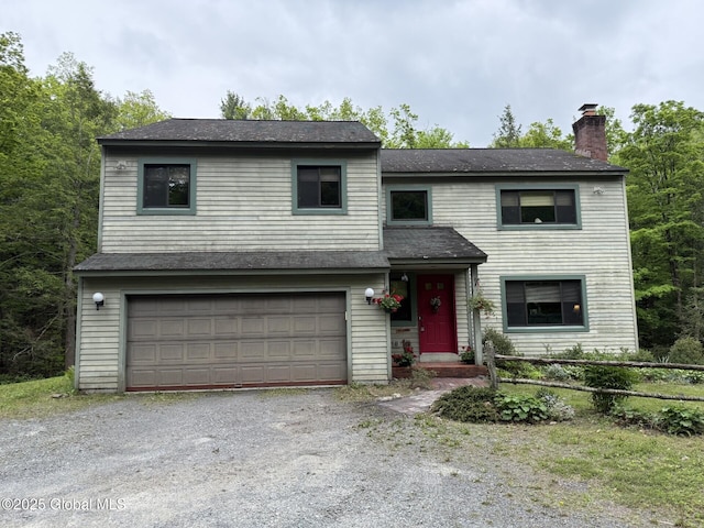 view of front of home featuring a garage, a chimney, gravel driveway, and a shingled roof