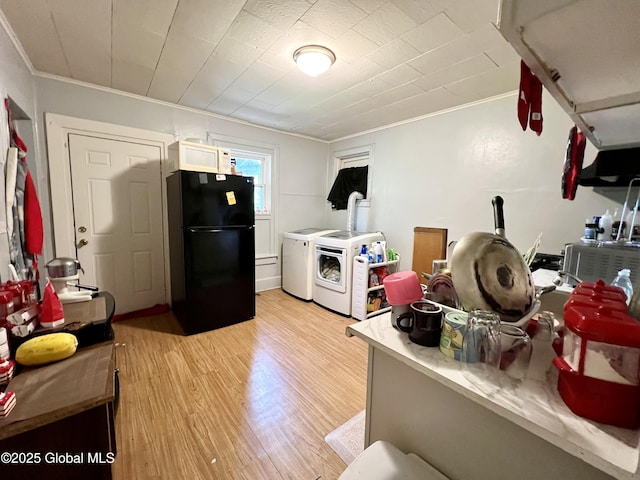 327 9th St, Troy, NY 12180 - kitchen with freestanding refrigerator, washing machine and clothes dryer, ornamental molding, light wood-style flooring, and light countertops