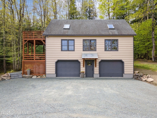 view of front facade featuring a garage, gravel driveway, and roof with shingles