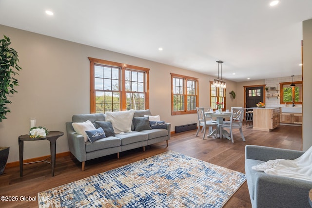 living room with baseboard heating, recessed lighting, dark wood-type flooring, and baseboards
