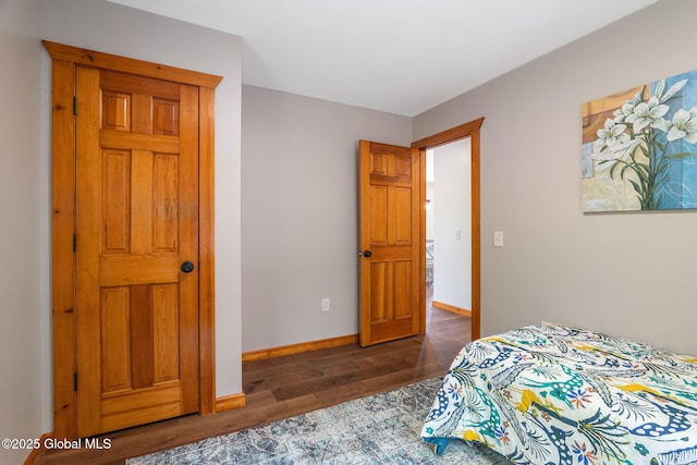 bedroom with dark wood-style floors and baseboards