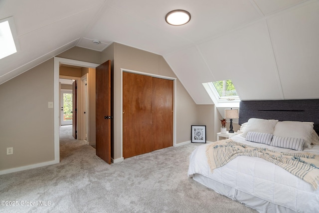 bedroom featuring a skylight, vaulted ceiling, carpet, and multiple windows