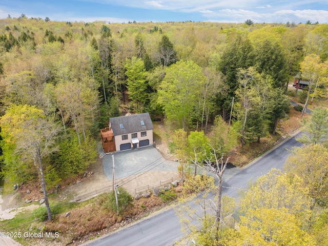 aerial view of property and surrounding area featuring a forest