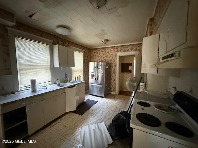 kitchen with white appliances, ventilation hood, light flooring, white cabinets, and light countertops