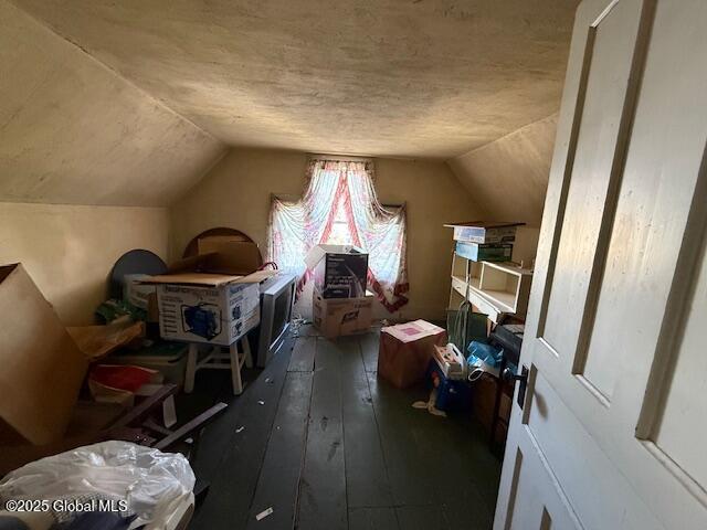 additional living space with vaulted ceiling and dark wood-type flooring