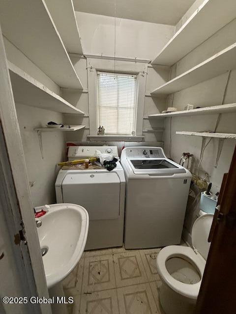 bathroom with washer and dryer, a sink, tile patterned floors, and toilet