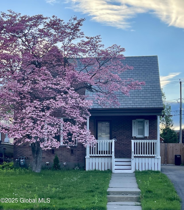130 Van Schoick Ave, Albany, NY 12209 - view of front facade featuring covered porch, brick siding, and fence