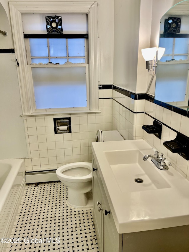 130 Van Schoick Ave, Albany, NY 12209 - bathroom featuring a baseboard radiator, tile walls, toilet, vanity, and wainscoting