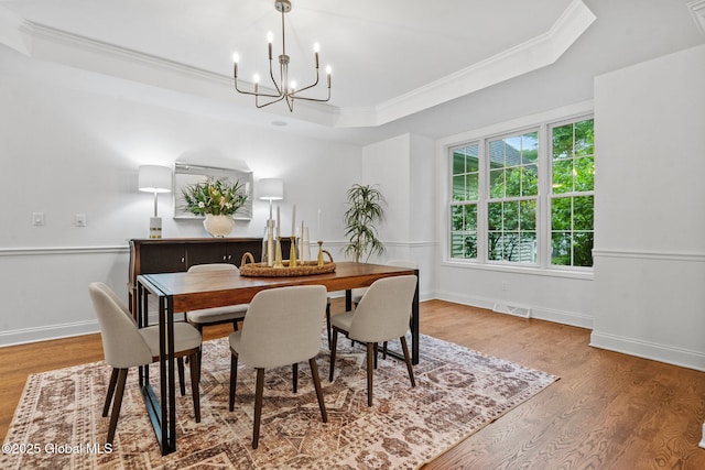 6004 Queen Mary Ct, Schenectady, NY 12303 - dining area with a raised ceiling, ornamental molding, a chandelier, wood finished floors, and baseboards
