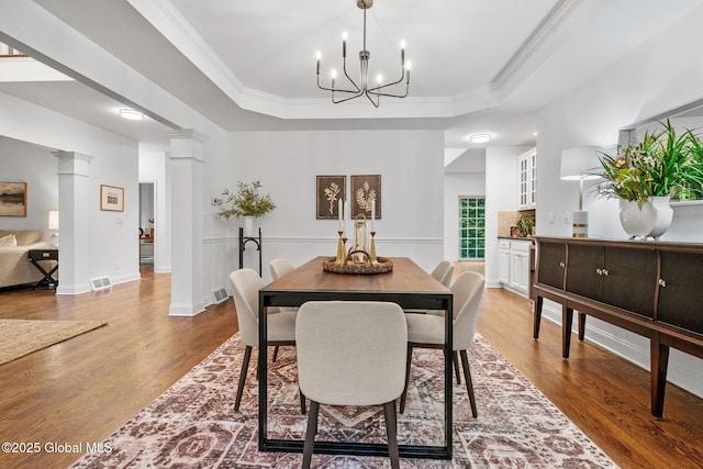 6004 Queen Mary Ct, Schenectady, NY 12303 - dining room featuring a raised ceiling, wood finished floors, decorative columns, a chandelier, and ornamental molding