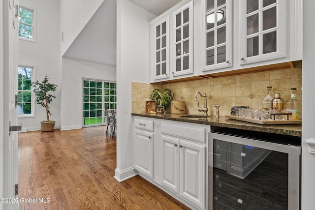 6004 Queen Mary Ct, Schenectady, NY 12303 - indoor wet bar with beverage cooler, wood finished floors, backsplash, baseboards, and a high ceiling