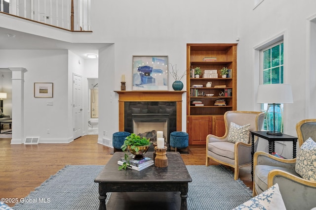 6004 Queen Mary Ct, Schenectady, NY 12303 - living room with a high ceiling, wood finished floors, a fireplace, baseboards, and ornate columns