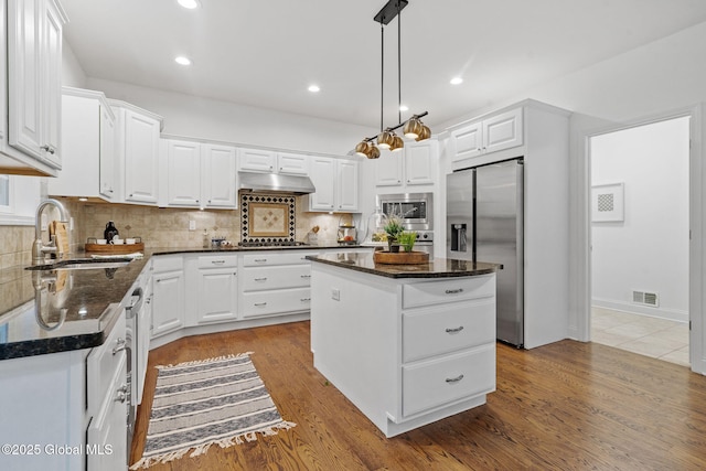 6004 Queen Mary Ct, Schenectady, NY 12303 - kitchen featuring stainless steel appliances, a sink, a kitchen island, under cabinet range hood, and decorative backsplash