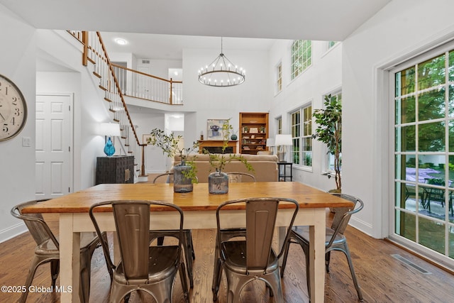 6004 Queen Mary Ct, Schenectady, NY 12303 - dining space featuring baseboards, wood finished floors, a towering ceiling, a chandelier, and stairway
