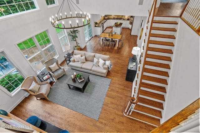 6004 Queen Mary Ct, Schenectady, NY 12303 - living area with stairway, wood finished floors, a chandelier, and a high ceiling
