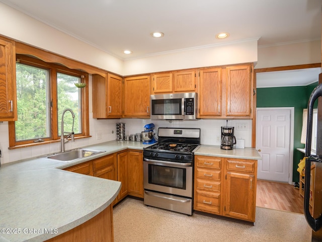 3 E St Stephens Ln, Glenville, NY 12302 - kitchen with appliances with stainless steel finishes, a sink, light countertops, backsplash, and ornamental molding