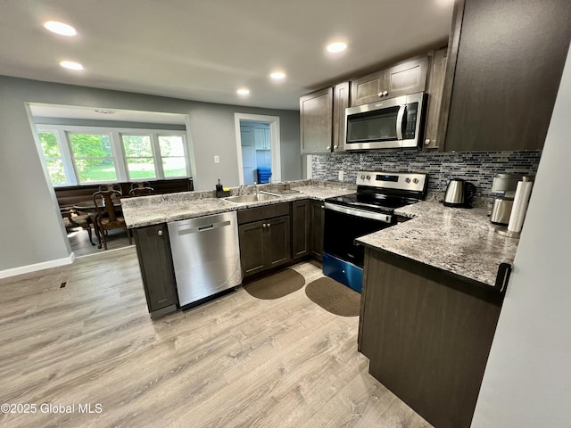 119 Houseman St, Mayfield, NY 12117 - kitchen with stainless steel appliances, a peninsula, light wood-style flooring, recessed lighting, and tasteful backsplash