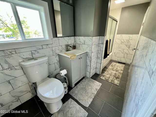 119 Houseman St, Mayfield, NY 12117 - bathroom with tile walls, an enclosed shower, a wainscoted wall, toilet, and vanity