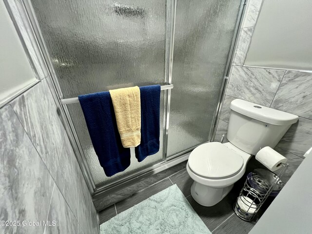 119 Houseman St, Mayfield, NY 12117 - bathroom featuring tile walls, toilet, and a stall shower