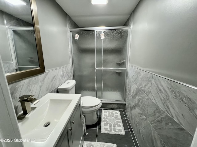 119 Houseman St, Mayfield, NY 12117 - bathroom with tile walls, wainscoting, a shower stall, vanity, and toilet