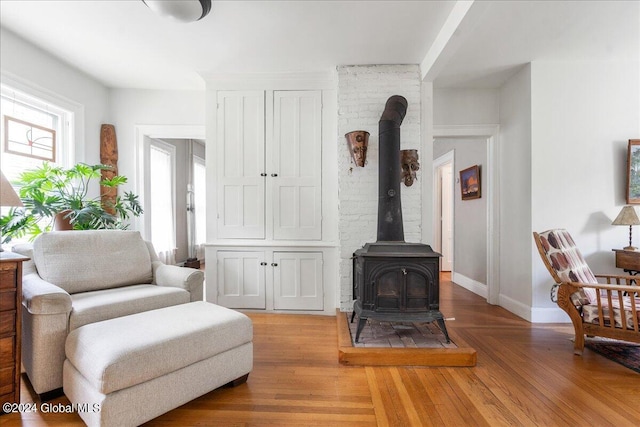 19 George St, Saratoga Springs, Inside, NY 12866 - living area featuring a wood stove, baseboards, and light wood-type flooring