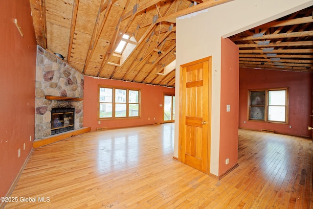 2188 Lynn St, Rotterdam, NY 12306 - unfurnished living room featuring hardwood / wood-style floors, a skylight, a fireplace, high vaulted ceiling, and beam ceiling