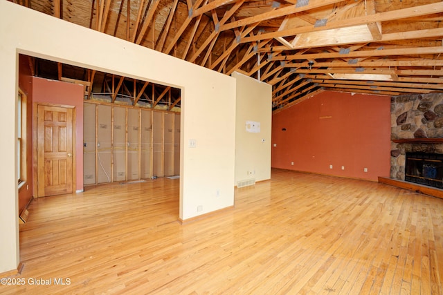 2188 Lynn St, Rotterdam, NY 12306 - unfurnished living room with wood-type flooring, a stone fireplace, and lofted ceiling