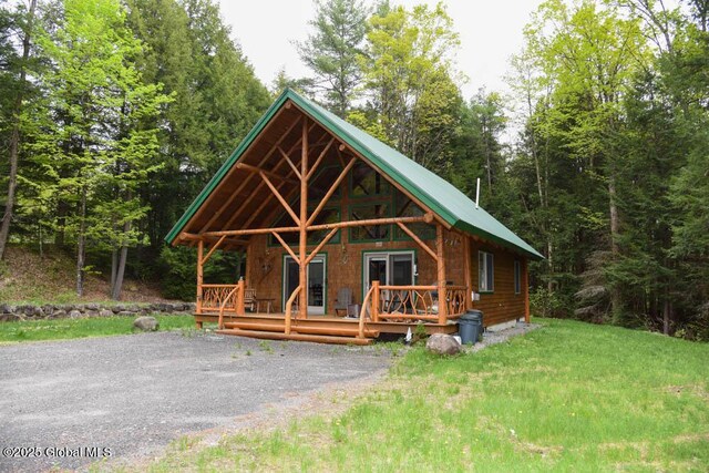 13 Dewey Rd, Chester, NY 12860 - view of front of property featuring covered porch, metal roof, a front lawn, and a view of trees