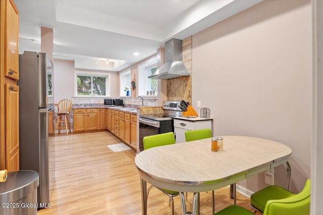 71 Hearthstone Dr, Wilton, NY 12831 - kitchen featuring wall chimney exhaust hood, appliances with stainless steel finishes, light wood finished floors, tasteful backsplash, and a sink