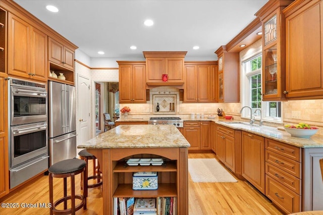 71 Hearthstone Dr, Wilton, NY 12831 - kitchen with open shelves, appliances with stainless steel finishes, a sink, a warming drawer, and light wood-type flooring