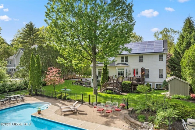 71 Hearthstone Dr, Wilton, NY 12831 - back of property featuring a deck, solar panels, a patio area, and an outbuilding
