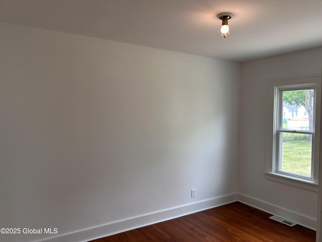unfurnished room featuring baseboards, plenty of natural light, and dark wood-style flooring