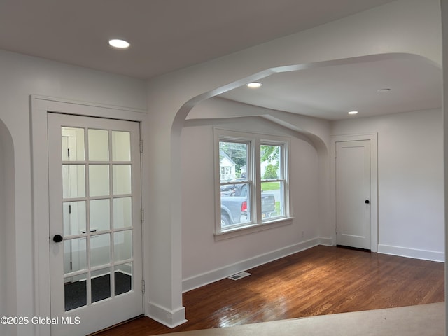 foyer entrance with arched walkways, dark wood-style floors, recessed lighting, and baseboards