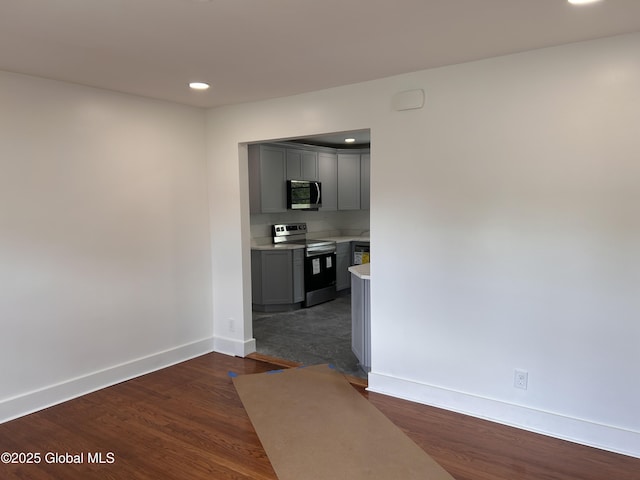 corridor with baseboards, recessed lighting, and dark wood finished floors
