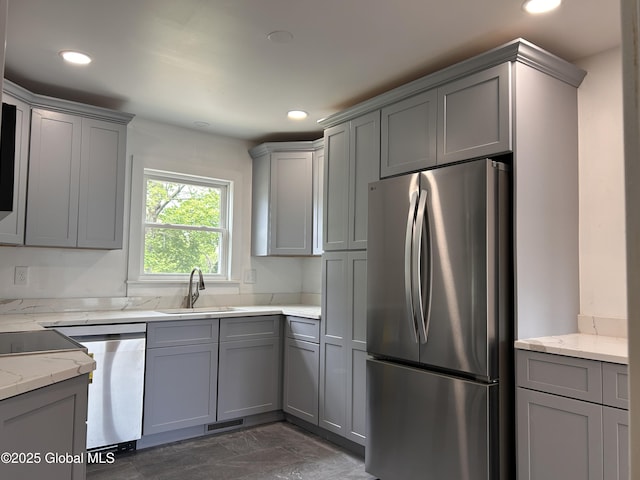 kitchen with freestanding refrigerator, gray cabinetry, a sink, recessed lighting, and light stone counters