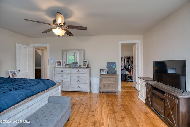 1409 Indian Fields Rd, Bethlehem, NY 12067 - bedroom featuring a walk in closet, light wood-style flooring, a closet, and a ceiling fan