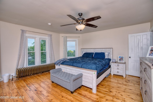 1409 Indian Fields Rd, Bethlehem, NY 12067 - bedroom with radiator heating unit, light wood-type flooring, a ceiling fan, and baseboards