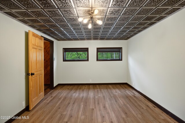401 Wilton Gansevoort Rd, Wilton, NY 12831 - empty room featuring an ornate ceiling, baseboards, light wood-style flooring, and a chandelier
