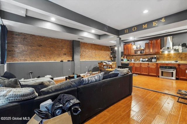 57 O Connell St, Albany, NY 12209 - living room featuring brick wall, light wood-style floors, recessed lighting, and decorative columns