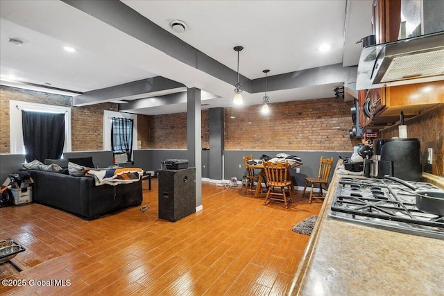 57 O Connell St, Albany, NY 12209 - kitchen with brick wall, wood finished floors, stainless steel gas cooktop, and decorative light fixtures