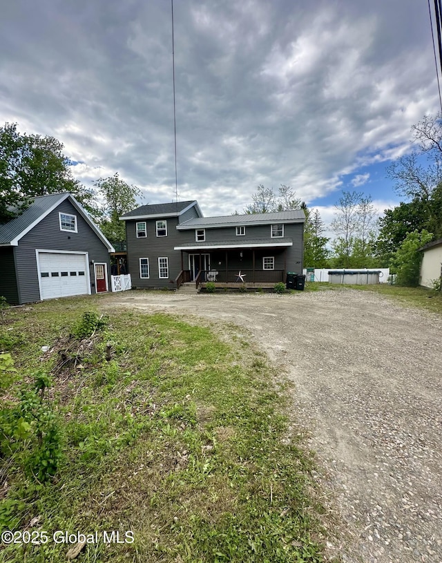 view of front of house featuring a detached garage, an outdoor structure, and driveway