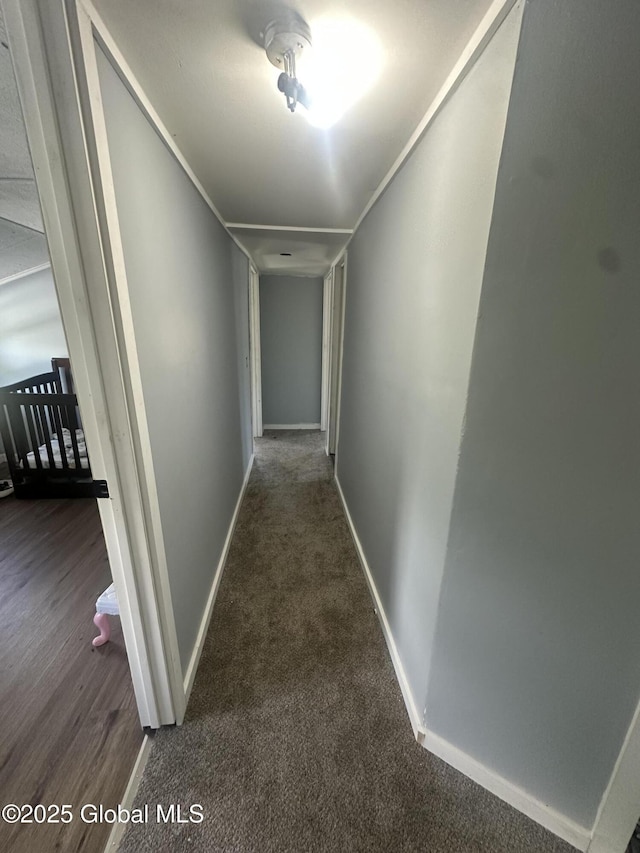 corridor with baseboards and carpet