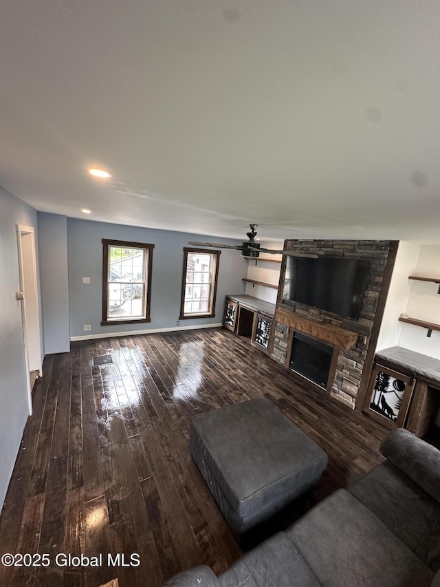 living room featuring wood-type flooring, a fireplace, ceiling fan, baseboards, and recessed lighting