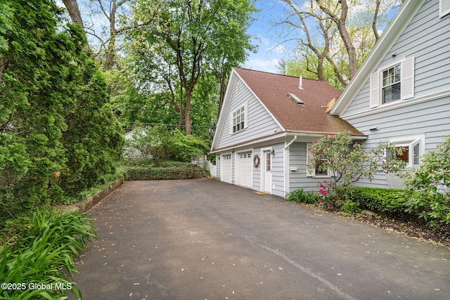 2 Loudon Pkwy, Colonie, NY 12211 - view of side of home featuring asphalt driveway, an attached garage, and a shingled roof